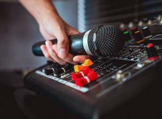 Hand Sound engineer  holding microphone on sound mixer in live broadcasting studio producer for...