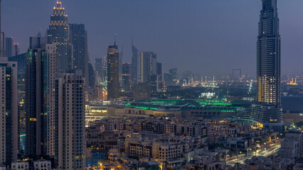 Dubai Downtown night to day timelapse. Aerial view over big futuristic city by night.
