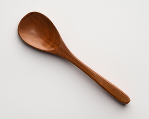 Empty wooden spoon on white