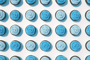 Vibrant Blue Frosted Cupcakes Arranged in Perfect Rows on Pristine White Surface