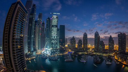 Aerial view of modern skyscrapers night to day timelapse before sunrise in Dubai Marina in Dubai, UAE.