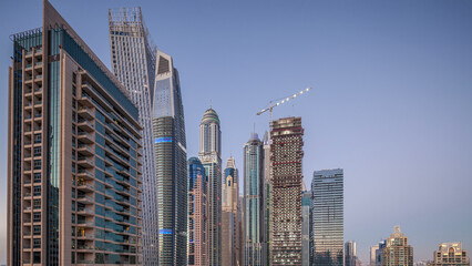 Fototapeta na wymiar Aerial view of modern skyscrapers day to night timelapse before sunrise in Dubai Marina in Dubai, UAE.