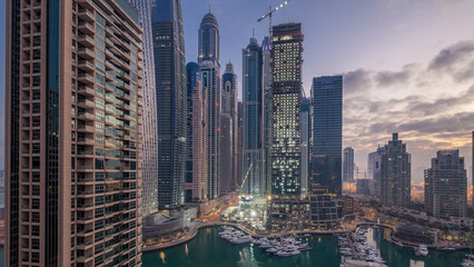 Aerial view of modern skyscrapers night to day timelapse before sunrise in Dubai Marina in Dubai,...