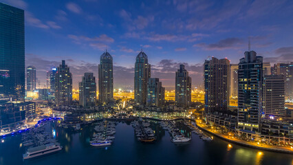 Aerial view of modern skyscrapers night to day timelapse before sunrise in Dubai Marina in Dubai, UAE.
