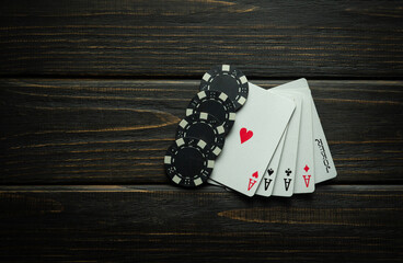 Card combination five of a kind aces and winning chips on a black table. Low key concept of major winning combination in poker club or casino - obrazy, fototapety, plakaty