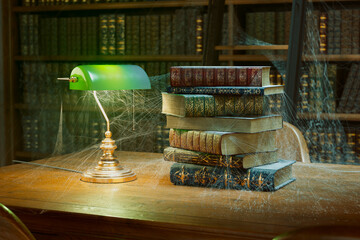 Evocative Scene of Age-old Books under Ambient Lamp Light Amidst Cobwebs - obrazy, fototapety, plakaty
