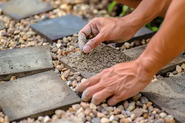 Foto op Canvas closeup of hands arranging decorative gravel around garden pavers © studioworkstock