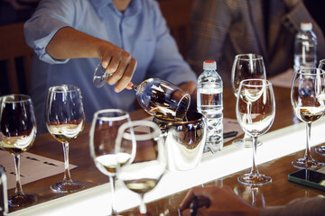 Close-Up View of Sommelier Pouring Wine Into Spittoon at Educational Wine School