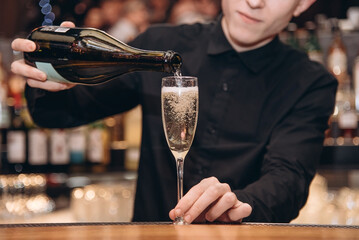 bartender pouring champagne into a glass