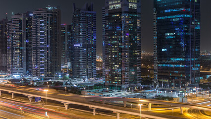Fototapeta na wymiar Aerial view of Jumeirah lakes towers skyscrapers night timelapse with traffic on sheikh zayed road.