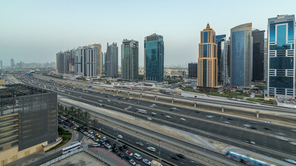 Fototapeta na wymiar Aerial view of Jumeirah lakes towers skyscrapers day to night timelapse with traffic on sheikh zayed road.