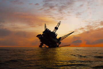 Sinking Oil Rig Against Fiery Sunset on the Ocean Horizon - Environmental Impact - 767121805