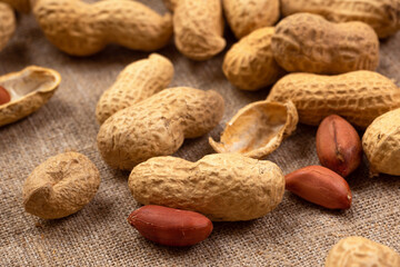 Roasted peanuts on burlap close-up. Peanut background - 767122801