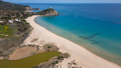 Aerial view of the Sardinian coast. Crystal clear sea of ​​Chia beach. Calm and sunny sea