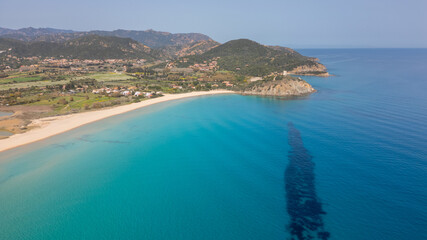 Fototapeta na wymiar Aerial view of the Sardinian coast. Crystal clear sea of ​​Chia beach. Calm and sunny sea