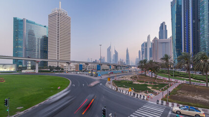 Fototapeta premium Traffic on intersection and bridge at the Sheikh Zayed Road day to night timelapse