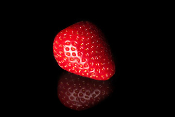 Ripe strawberries on a black background with reflection. - 767125699