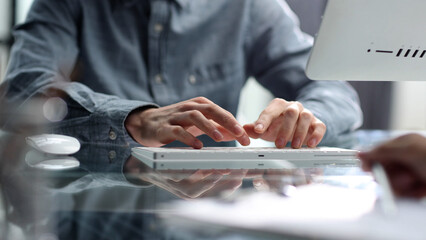 Working with a computer and documents at a desk in close-up in the office