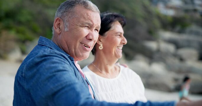 Nature, beach and elderly couple with point for holiday, travel and sightseeing on vacation in California. Happy, people and adventure by ocean with gesture for view, direction and retirement getaway