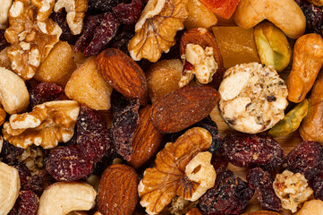 Top view pile of dried colorful breakfast mix nuts and fruits, background, closeup, horizontal.