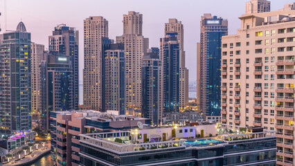 Aerial view of Dubai Marina after sunset from a vantage point day to night timelapse.