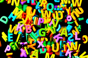 Colorful 3D Alphabet Letters Scattered Playfully on a Dark Background - 767133041