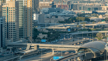 Futuristic building of Dubai metro and tram station and luxury skyscrapers behind timelapse