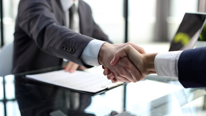 Businessmen in the office talking in close-up and shaking hands