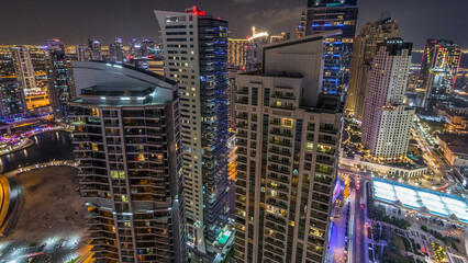 Aerial view of modern illuminated skyscrapers at Jumeirah Beach Residence JBR and Dubai marina night timelapse in Dubai, UAE