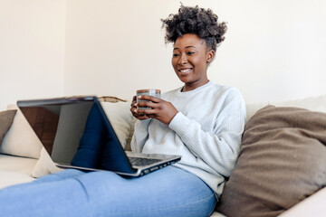 ..Young black woman working from home. Using laptop for video business meeting