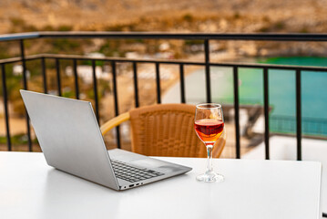 Laptop and a glass of wine. An ideal place for remote work. - 767149837