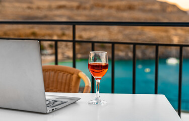 Laptop and a glass of wine. An ideal place for remote work. - 767149838
