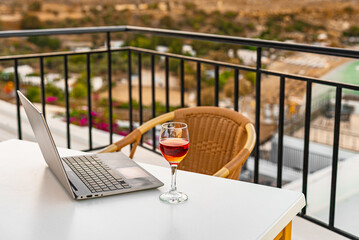 Laptop and a glass of wine. An ideal place for remote work. - 767149855