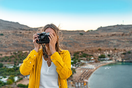 Woman photographer takes pictures on vacation.