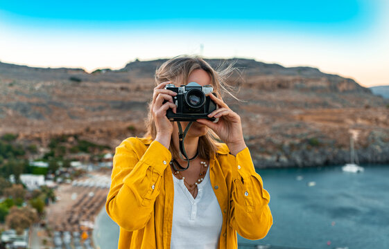 Woman photographer takes pictures on vacation.