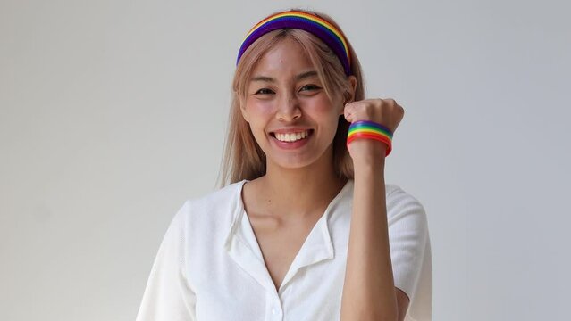 Empowerment and Pride: Happy LGBT Woman Wearing Rainbow Wristband and Headband