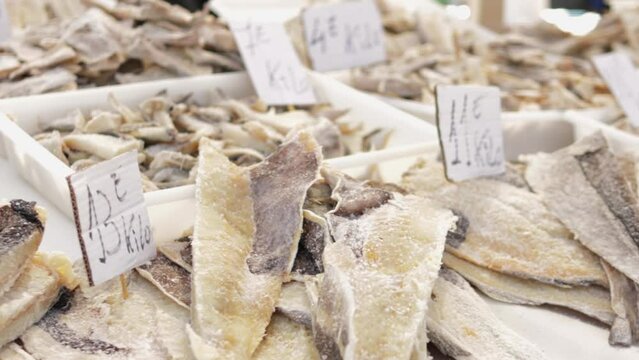 Wide array dried fish is meticulously arranged  farmer market counter, showcasing diverse selection available. Concept of artisanal shopping, patrons seek out unique and traditional food items