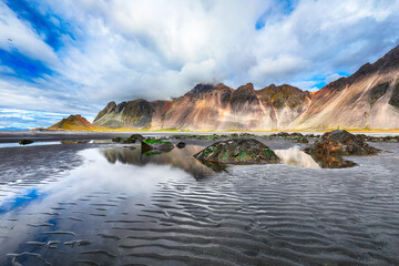 Dramatic sunny day and gorgeous rippled black sand beach  on Stokksnes cape in Iceland.