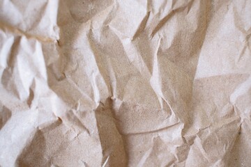 Crumpled craft paper background. Texture of brown crumpled paper, top view. Packaging material.