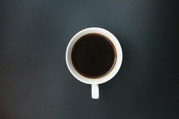 black coffee poured into a porcelain coffee cup on a black background