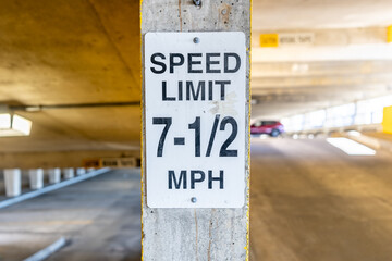 Odd 7-1/2 MPH speed limit sign within a parking garage. - obrazy, fototapety, plakaty