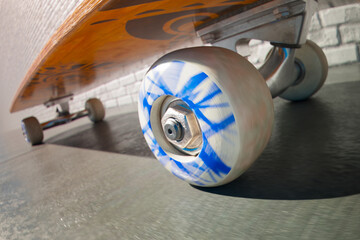 Close-Up Dynamic Spin: Skateboard Wheel in Motion Against Urban Backdrop - 767160018