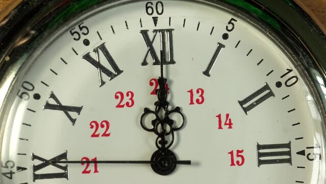 A timelapse rotating close up of the face of a pocket watch passing 12 o'clock midnight or midday.