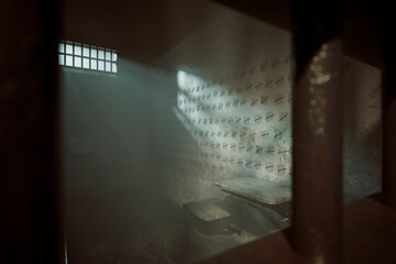 Abandoned Prison Cell: Sunlight Streaming Through Window on Tally Marks