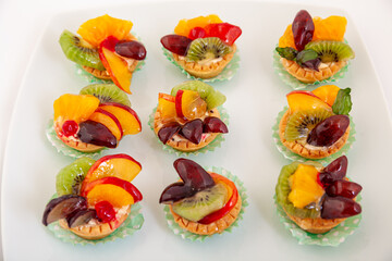 Delicious fruit tartlets dessert. Assorted tarts, pastry cakes sweets with fresh fruits