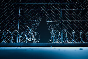 Night Emerges: The Eerie Scene of a Broken Security Fence Under the Moonlight