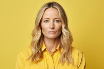 Portrait of a beautiful blonde woman in yellow shirt on yellow background