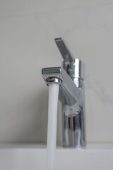 Chrome water faucet with flowing water 