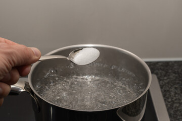 cooking in the kitchen - put salt in hot bowl water in pan 