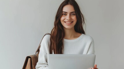 Smiling young attractive woman holding a purse, sits at the laptop, light grey background, concept: online shopping, text and copy space, 16:9